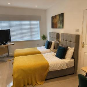 1 Schlafzimmer mit 2 Betten und gelben Decken in der Unterkunft Flexistay Studio at Watford in Watford