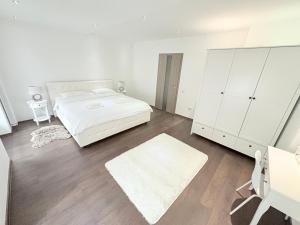 ein weißes Schlafzimmer mit einem Bett und einem weißen Schrank in der Unterkunft Old City Poema in Braşov