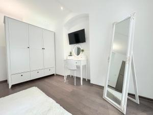 ein weißes Schlafzimmer mit einem Spiegel und einem Schreibtisch in der Unterkunft Old City Poema in Braşov