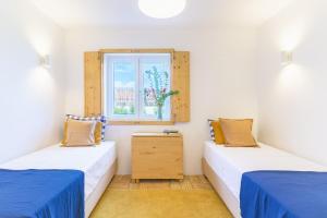 two twin beds in a room with a window at Casa do Medronheiro in Melides +32 photos