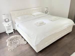 ein weißes Bett mit zwei Handtüchern darauf in der Unterkunft Old City Poema in Braşov + 44 Fotos