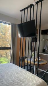 ein Schlafzimmer mit einem Bett und einem Flachbildfernseher in der Unterkunft Studio Coral en la mejor Zona de Cochabamba in Cochabamba