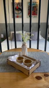 Ein Tablett mit zwei Schüsseln auf einem Tisch mit einer Vase in der Unterkunft Studio Coral en la mejor Zona de Cochabamba in Cochabamba