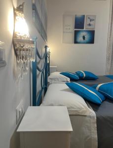 two beds with blue pillows in a room at CASA PAOLINA NEL CENTRO DI BRACCIANO in Bracciano
