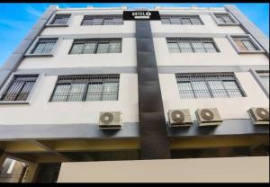 Un edificio alto y blanco con un cartel. en Magadh Kutumb Guest House, en Patna