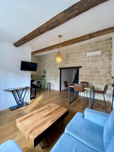 ein Wohnzimmer mit Sofa und Tisch in der Unterkunft Le petit Corum - HH - Centre historique in Montpellier