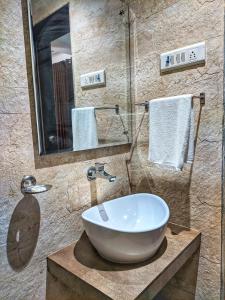 une salle de bain avec un lavabo et un miroir dans l'établissement Ice Apple Resort By Vintara Stays, à Nagaon