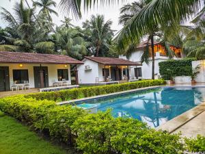 une villa avec piscine devant une maison dans l'établissement Ice Apple Resort By Vintara Stays, à Nagaon 20 autres photos