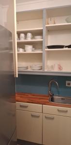 Una cocina con fregadero y gabinetes blancos. en Patrikapartman2, en Viena