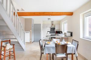une cuisine et une salle à manger avec une table et des chaises dans l'établissement Appartement agréable proche Colmar, à Andolsheim