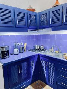 eine blaue Küche mit blauen Schränken und einer Spüle in der Unterkunft Maison beldi Essaouira in Rabat + 21 Fotos