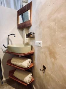 ein Badezimmer mit einem Waschbecken und einem Spiegel an der Wand in der Unterkunft Maison beldi Essaouira in Rabat