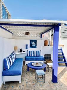 eine Terrasse mit blauen Sofas und einem Tisch in der Unterkunft Maison beldi Essaouira in Rabat