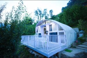 Una pequeña casa de iguana blanca en un jardín. en The Lush Pods, en Haripūr