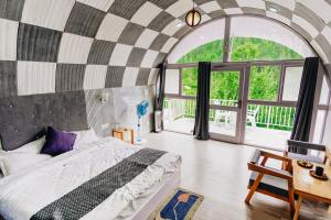 Un dormitorio con una cama y una ventana grande en The Lush Pods, en Haripūr