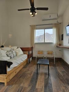 ein Schlafzimmer mit einem Bett und einem Tisch und einem Fenster in der Unterkunft Vistas del Yásta cabaña para un solo grupo in Cafayate