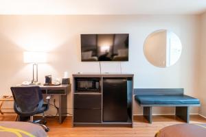 une pièce avec un bureau, un micro-ondes et une chaise dans l'établissement Super 8 by Wyndham Gananoque - Country Squire Resort, à Gananoque