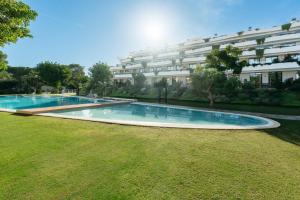 a swimming pool in front of a building at Apartamentos - Delfin Natura in L'Alfas del Pi