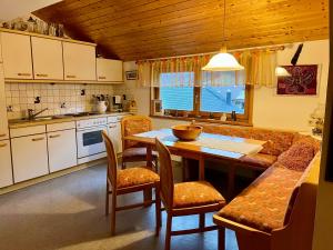 a kitchen with a table and chairs and a couch at Dahoam by David in Oberweissburg +19 photos