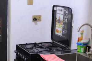a black stove top oven sitting next to a sink at Quick Connect Studio Kileleshwa in Nairobi +23 photos