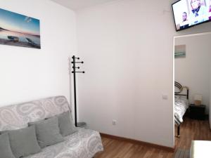 ein Wohnzimmer mit Couch und Flachbildfernseher in der Unterkunft A casinha in Nazaré