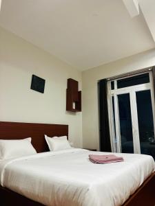 a bedroom with a large white bed with a window at Casa eka in Ooty