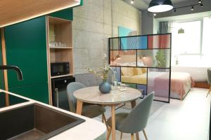 地拉那Ambassador Skyline Apartments的一间带桌椅的房间和一间卧室