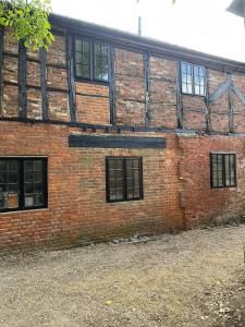 - un bâtiment en briques avec des fenêtres sur le côté dans l'établissement The Merchants Barn - A New Unique Town Centre Home, à King's Lynn