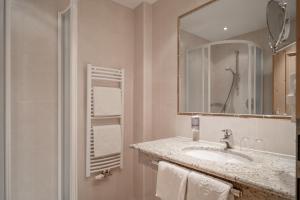 een badkamer met een wastafel, een spiegel en een douche bij Alpenresidenz am Mühlbach in Obergurgl