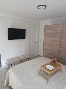 a bedroom with a bed with a table and a tv at Loft paradisse in Melilla +22 photos