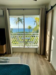 Un dormitorio con una ventana con vista al mar. en Le PARADIS BLEU VUE MER, en Saint-François