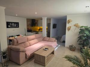 a living room with a pink couch and a table at Loft paradisse in Melilla
