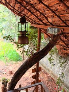 eine Glocke, die an einem Holzgestell mit einem Schild hängt in der Unterkunft Elephant point tree house in Sigiriya