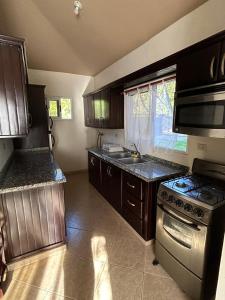 Una cocina con gabinetes de madera y un horno de estufa. en Nice villa near the beach, en Cabarete