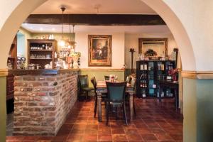a restaurant with a brick wall and a table and chairs at Gasterij de Poort in Gulpen