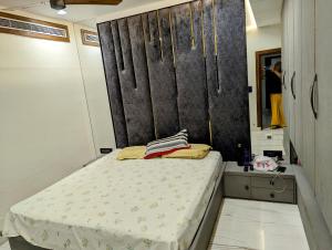 ein kleines Schlafzimmer mit einem Bett und einem Spiegel in der Unterkunft The Agra Lux- Elite Villa in Agra