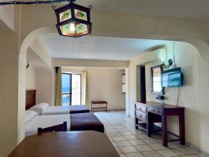 a living room with a bed and a table in a room at Hotel Hacienda María Eugenia Acapulco in Acapulco