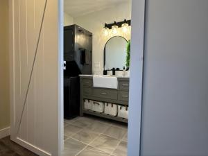 a bathroom with a sink and a mirror at Oceanfront Cottage w/ Upper Balcony View in Summerside +6 photos