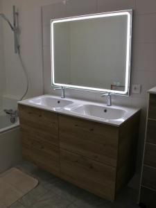 ein Badezimmer mit Waschbecken und großem Spiegel in der Unterkunft Maison cosy - Logis Flo - à 15 min du Futuroscope in Beaumont + 33 Fotos