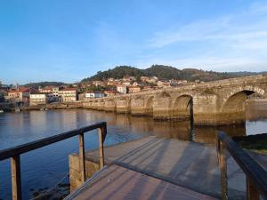 a bridge over a river next to a city at Piedra Miranda in Vilaboa