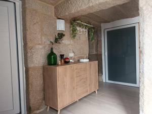 a wooden cabinet with a green vase on it next to a door at Piedra Miranda in Vilaboa +50 photos