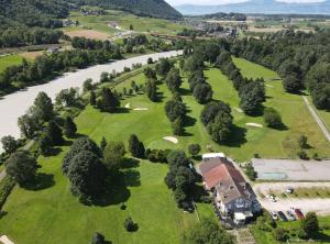 an aerial view of a golf course next to a river at Lake Geneva in Port-Valais