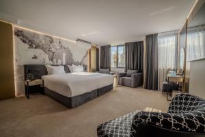 a hotel room with a bed and a couch and chairs at Aslan Gold Hotel in Varna City