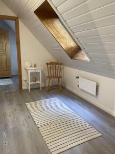 a attic room with a skylight and a chair and a rug at Ferienhaus Im Fachwerkstil Mit Sauna Und Garten in Thomasburg