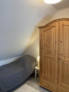 a bedroom with a bed and a wooden cabinet at Ferienhaus Im Fachwerkstil Mit Sauna Und Garten in Thomasburg