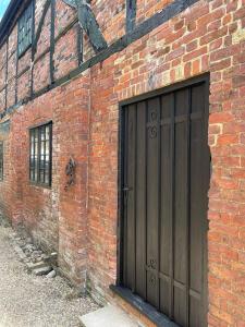 un bâtiment en briques avec une porte de garage en bois dans l'établissement Bishops Keep - A New Unique Town Centre Home, à King's Lynn