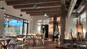 a restaurant with tables and chairs and a large window at Apartmány a chatky Camp Telč - U Roštěnky in Telč