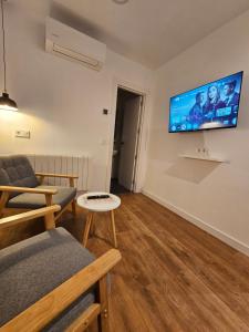 a living room with a couch and a tv on the wall at Hostal Arenal Madrid in Madrid