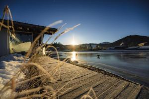 a view of the sun setting over a frozen lake at Haubers Naturresort in Oberstaufen