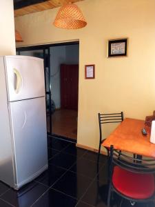 a kitchen with a table and a white refrigerator at La casa de las flores in Las Heras +3 photos